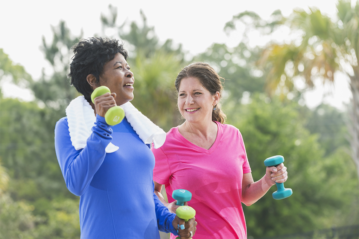 Two women walking with dumbbells outside