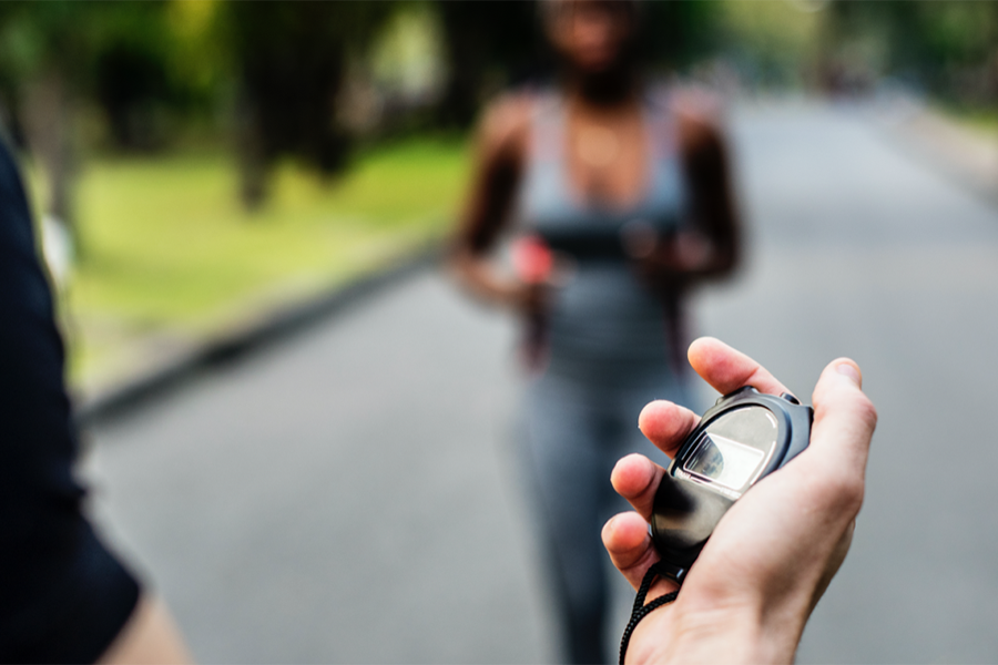 Person tracking a runner with a stop watch
