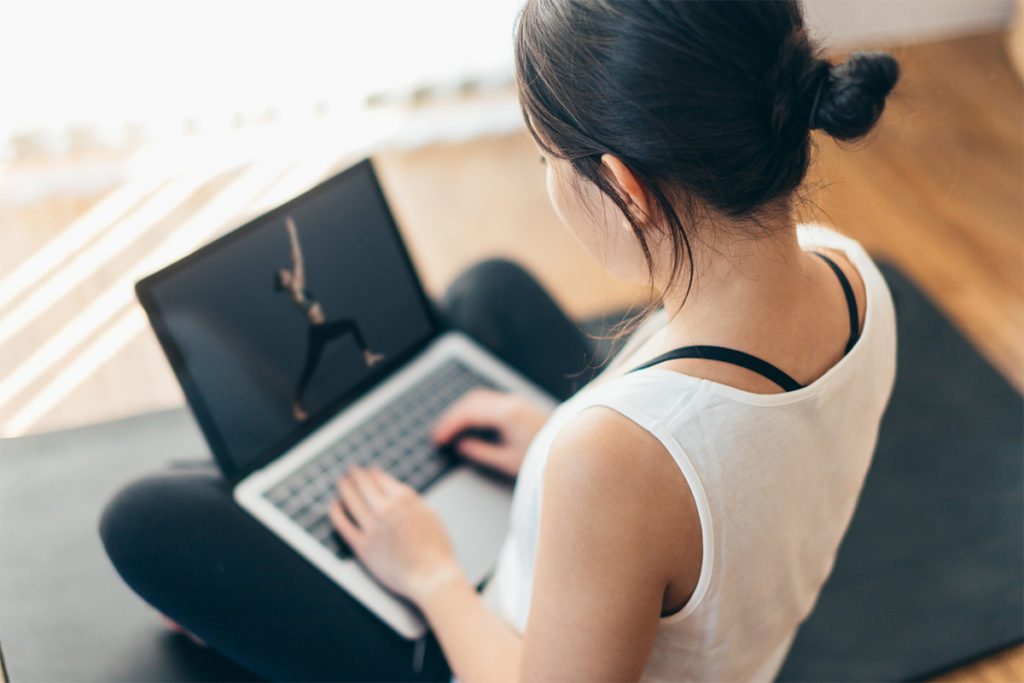 Woman looking at a virtual fitness class on her laptop