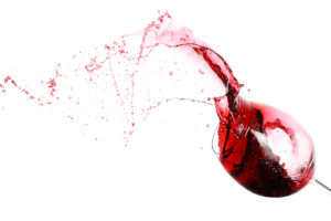 A glass of red wine spilling