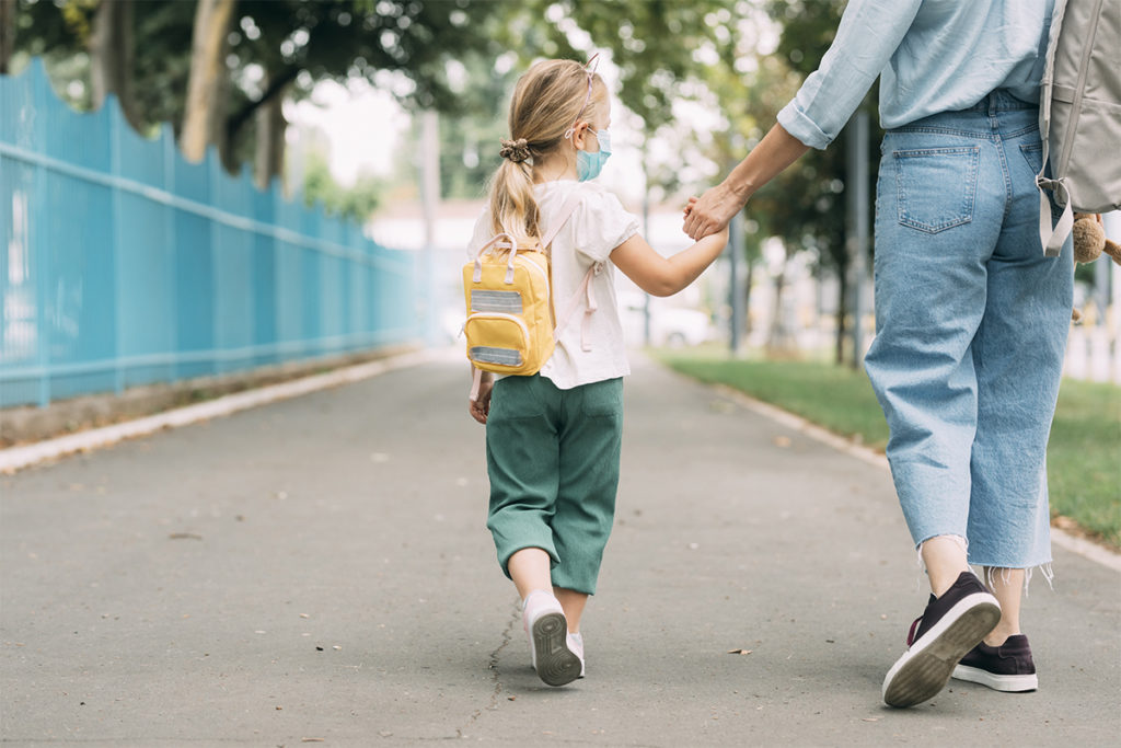 Small child walking with a backpack