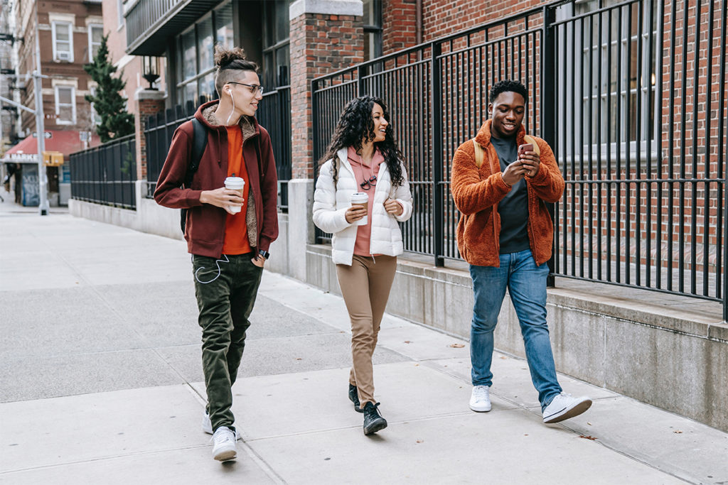 Three young adults walking and engaging in light physical activity
