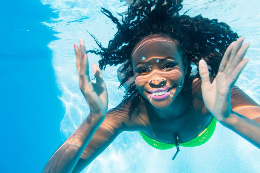 A woman swimming and practicing pool fitness in the water