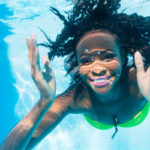 A woman swimming and practicing pool fitness in the water