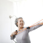 An older woman doing resistance band training