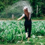 woman watering vegetable garden using functional training