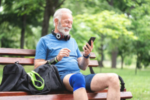 Older man sitting on a bench with knee pain