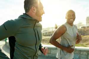 Two men running together smiling to show link between exercise and mental health