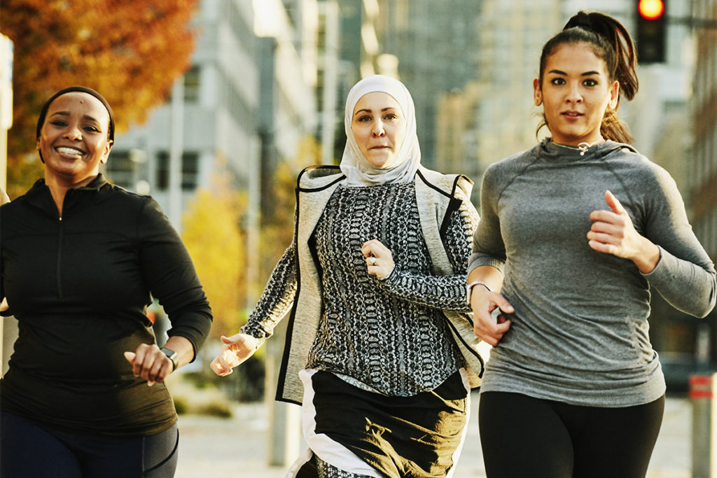 Fitness and health motivation shown with women running together on a street