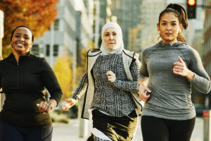 Fitness and health motivation shown with women running together on a street