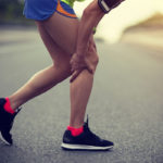 Person gripping their leg in pain on a run