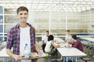 Boy holding a student meal at school