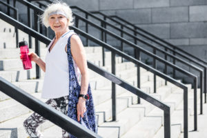 Older woman testing heart health walking up stairs