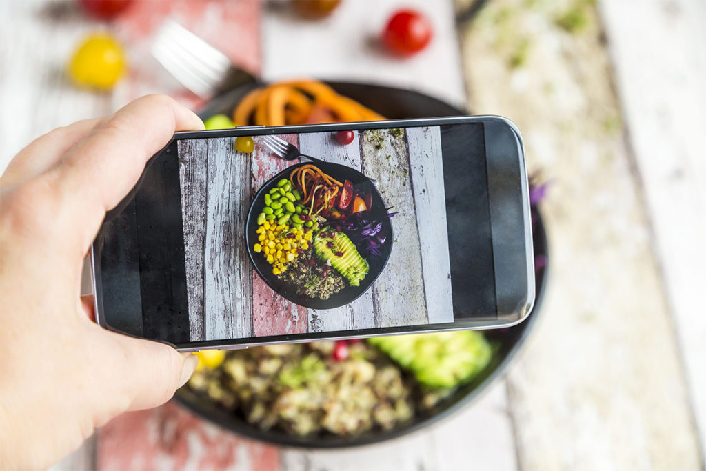 Person taking photo of food to illustrate food aesthetics