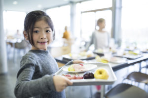 Child holding tray of school food