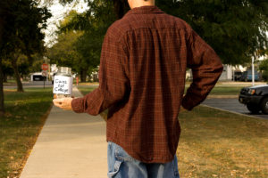 Person standing with a jar that says "coins for college" to represent food insecurity