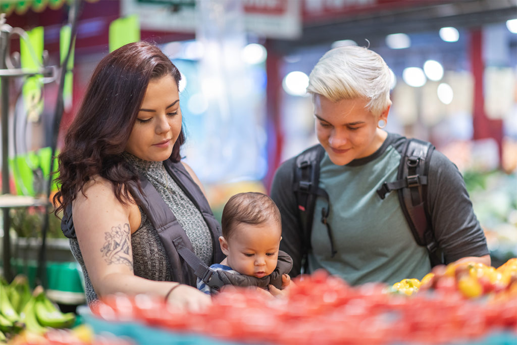 Lesbian couple grocery shopping to represent food insecurity demographic