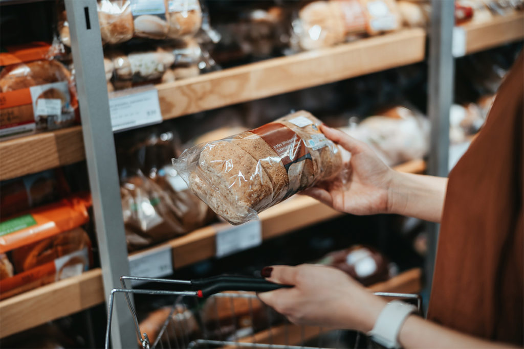 Person holding packaged bread with refined grains