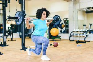 Woman weight lifting to show link between strength training and weight loss