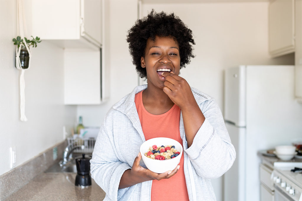 Woman using tips to cut calories by eating a healthy breakfast in the kitchen