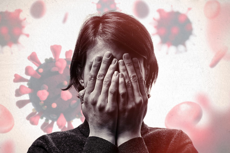 Person covering face and coping with grief