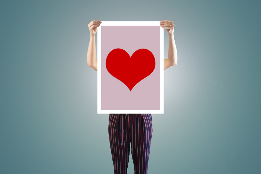 Person holding up image of heart to represent heart disease