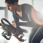 Woman lowering exercise time on stationary bike