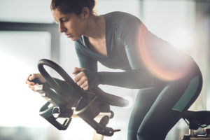 Woman lowering exercise time on stationary bike