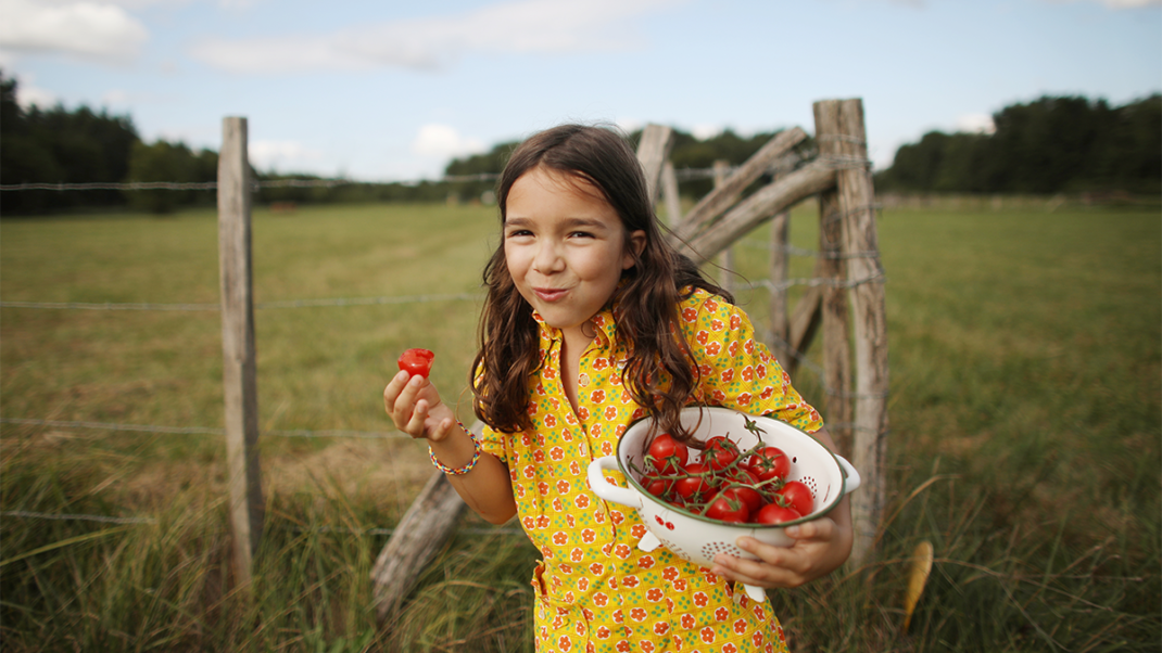 Young girl eating fruit as part of plant-based diet