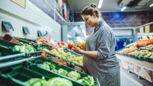 Woman grocery shopping for diet during pregnancy