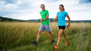 Two people enjoying Nordic walking benefits outside