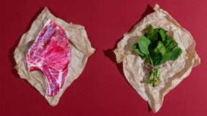 Piece of meat next to spinach to show pros and cons of plant-based eating