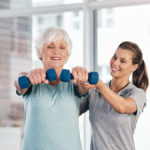 Trainer helping client with exercise and multiple sclerosis
