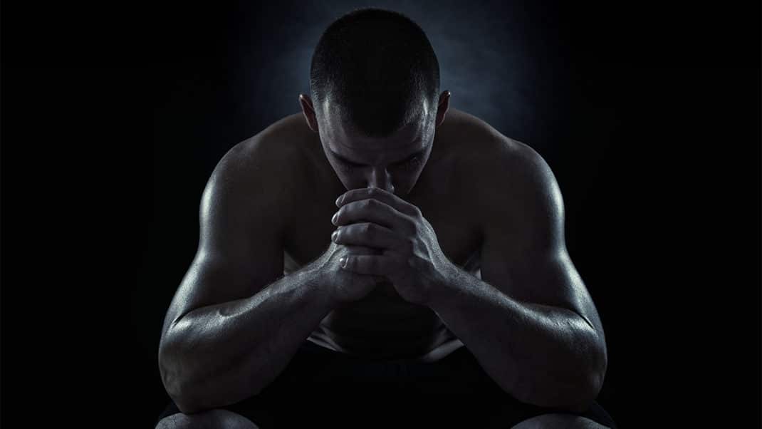 Dark image of man with head down to show use of exercise for depression