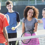 Teenagers getting their daily activity on a tennis court