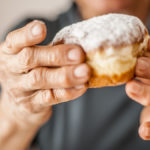 Older person holding a donut to show poor diet trends in older adults