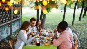 People outside at a table eating healthy holiday substitutions