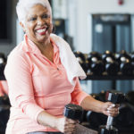 Older woman with dumbbells using muscle strengthening for longevity