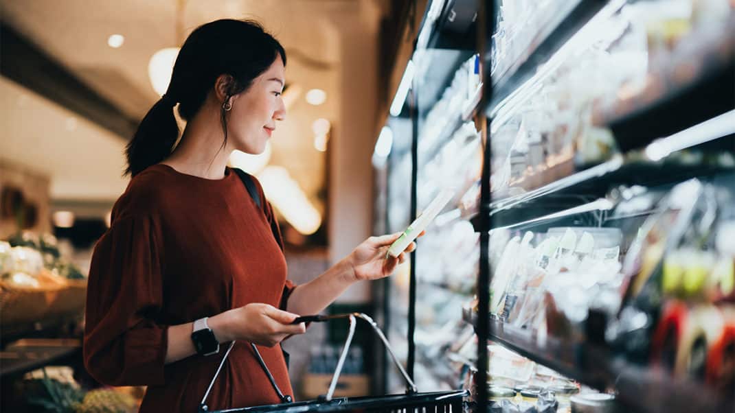 Woman looking at nutrition labels at the grocery store