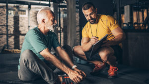 Personal trainer discussing medications and exercise with older client