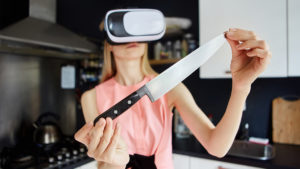 Woman with vr headset holding knife in kitchen to show virtual reality nutrition