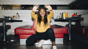 Young woman doing exercise after eating in restaurant