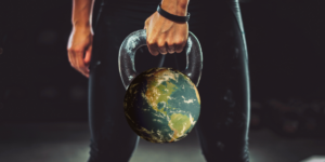 Person holding kettlebell that has the World transposed on it