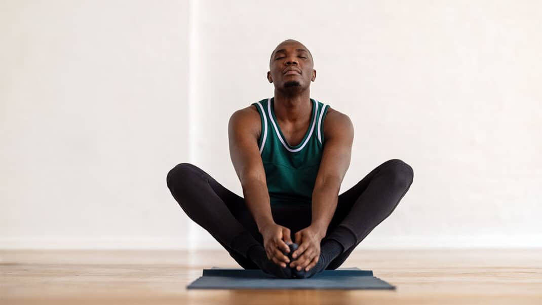 Man doing yoga for low-intensity training