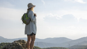 Woman hiking outdoors for summer self-care tips