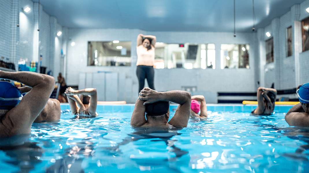 Fitness class experiencing pool coaching from instuctor