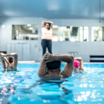 Fitness class experiencing pool coaching from instuctor