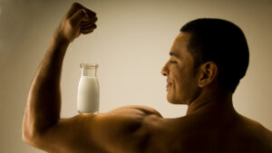 Man flexing with milk to illustrate protein timing